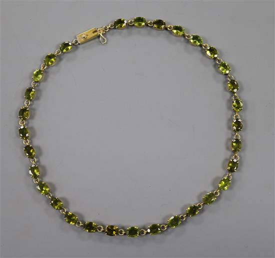 A mid 20th century gilt white metal and oval cut peridot set necklace, 40.5cm.